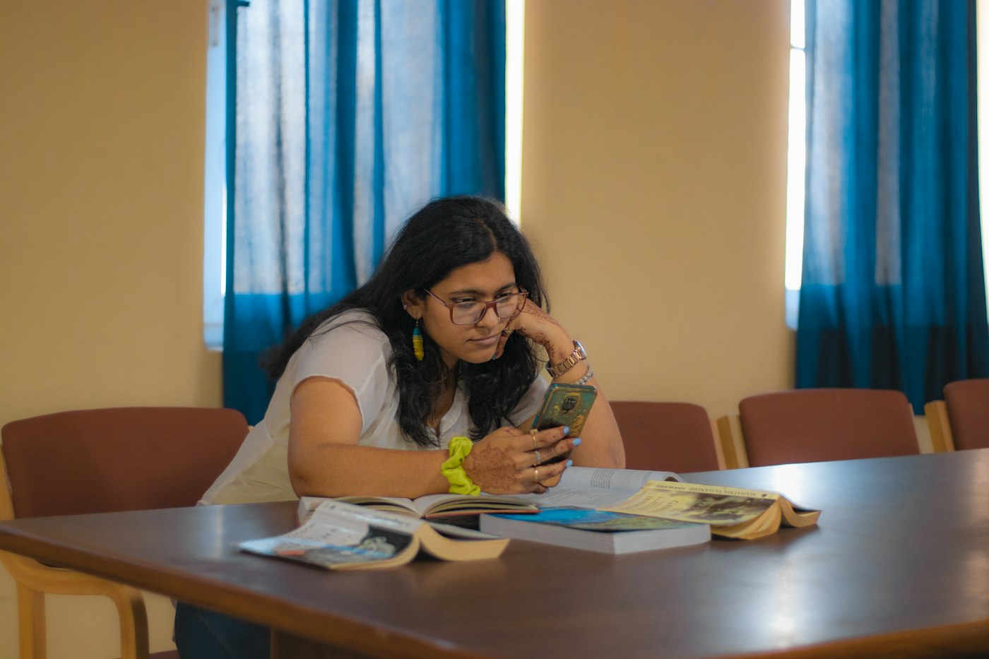 Estudiante repasando con el celular en un aula vacía